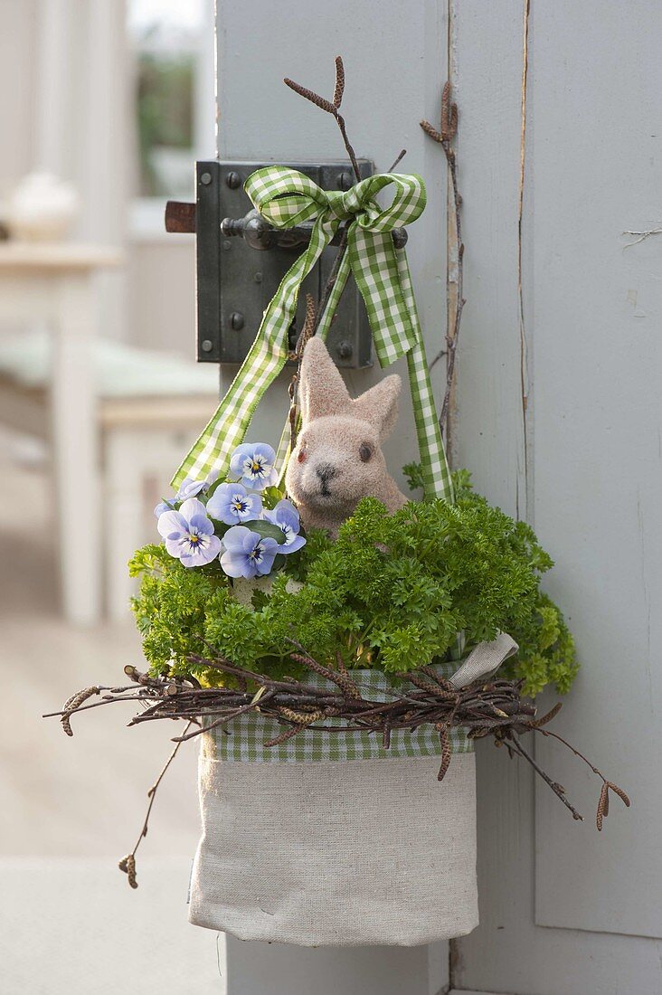 Cloth bag in wreath of betula branches with parsley