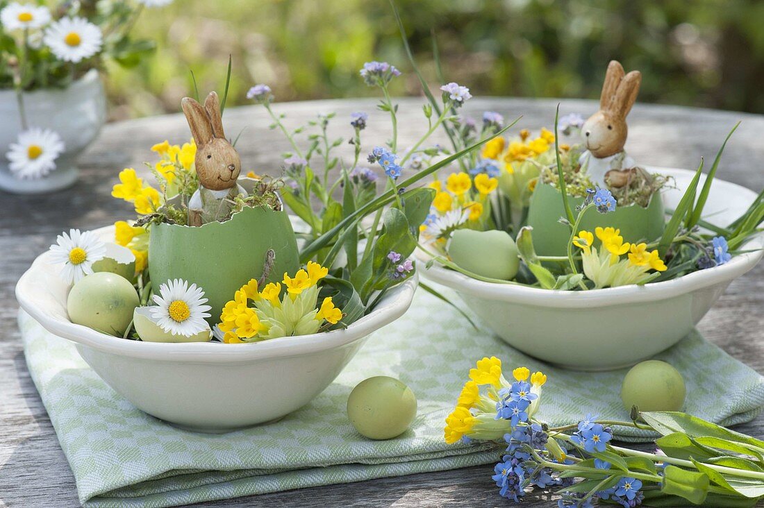 Easter bunnies in eggshells with primula veris (cowslip)
