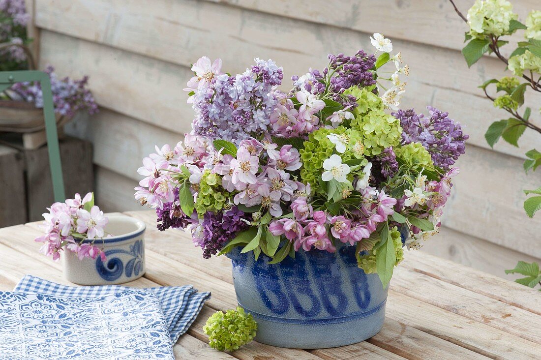 Spring bouquet in salted glass pot, viburnum, syringa