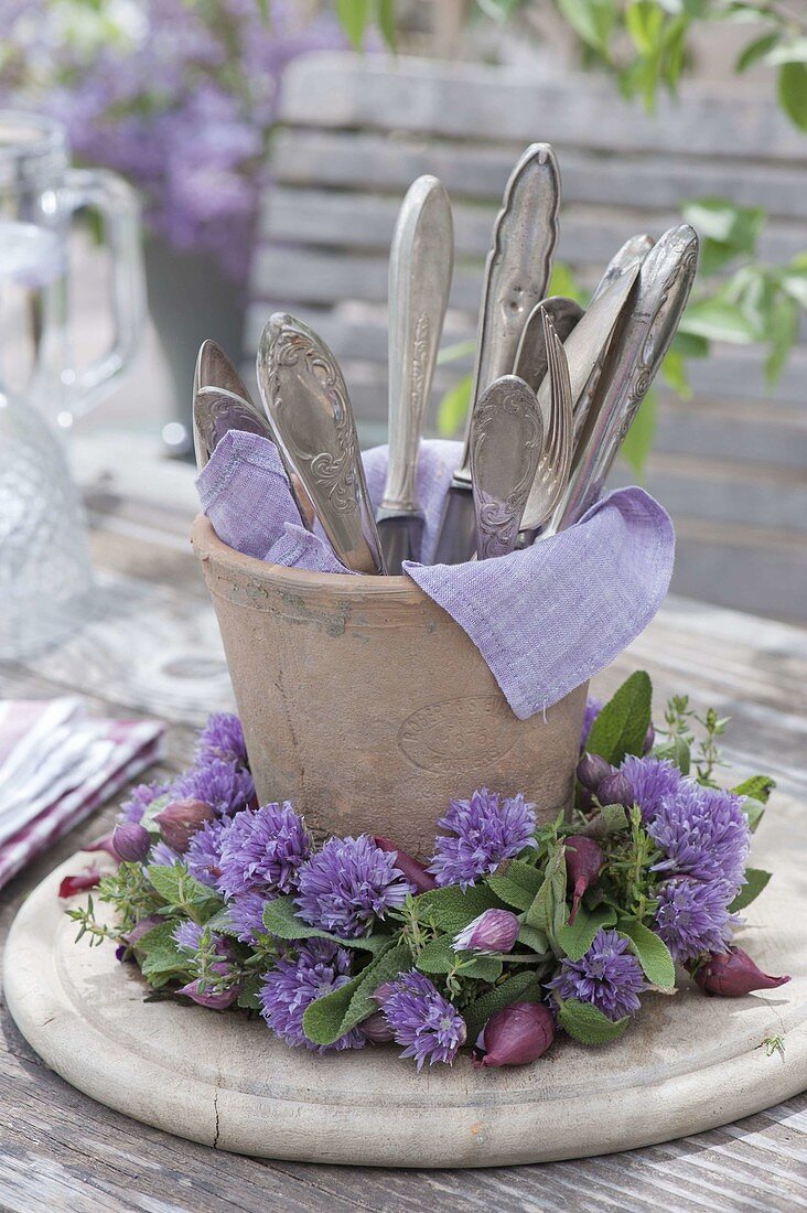 Terracotta vase with cutlery in chives flowers wreath