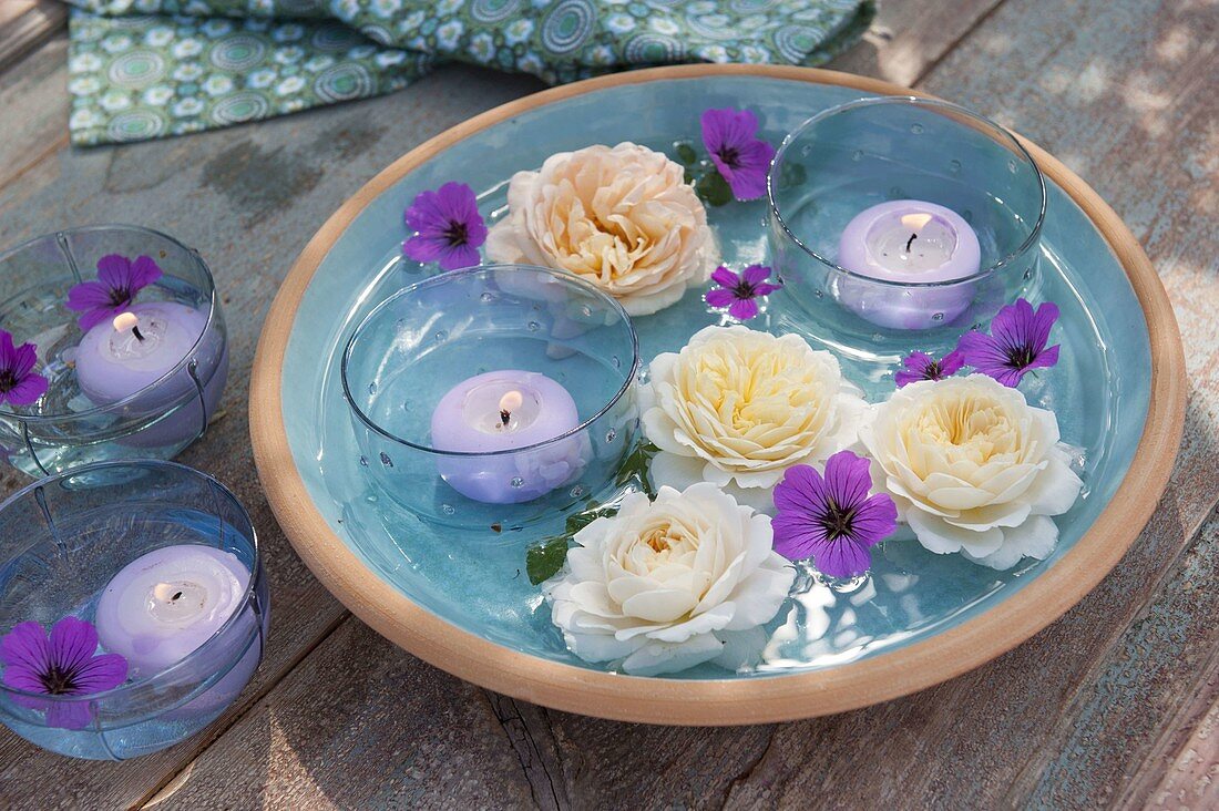 Glass bowls with floating candles as lanterns, flowers of pink