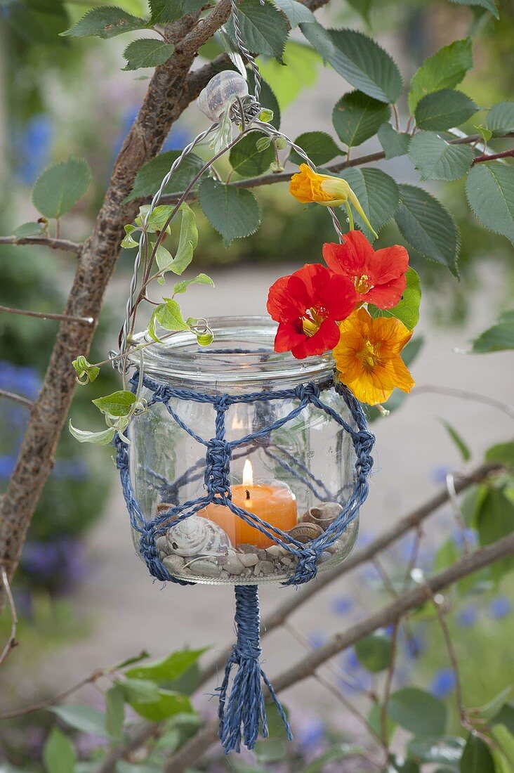 Einmachglas mit Makramee als Windlicht an Baum