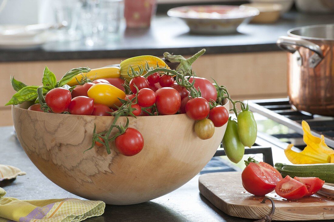 Holz-Schale mit frisch geernteten Tomaten (Lycopersicon), Zucchini (Cucurbita