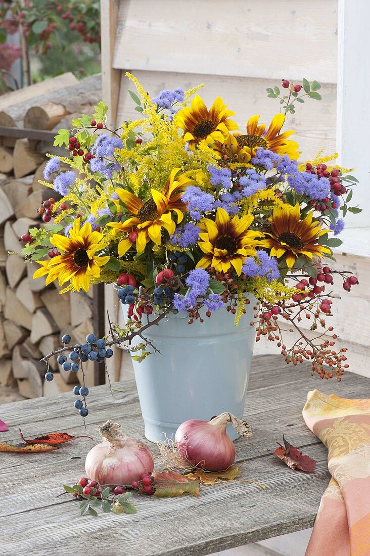 Cottage bouquet with Helianthus 'Ring of Fire', rose hips