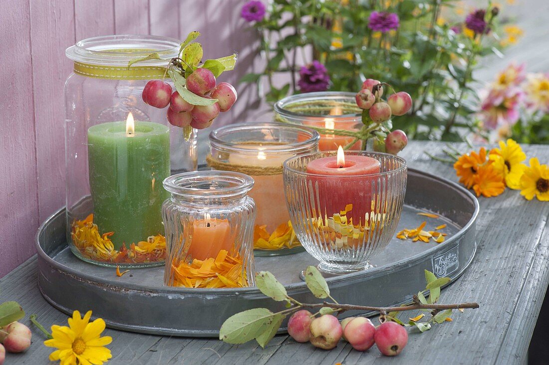 Glasses with candles as lanterns on metal tray