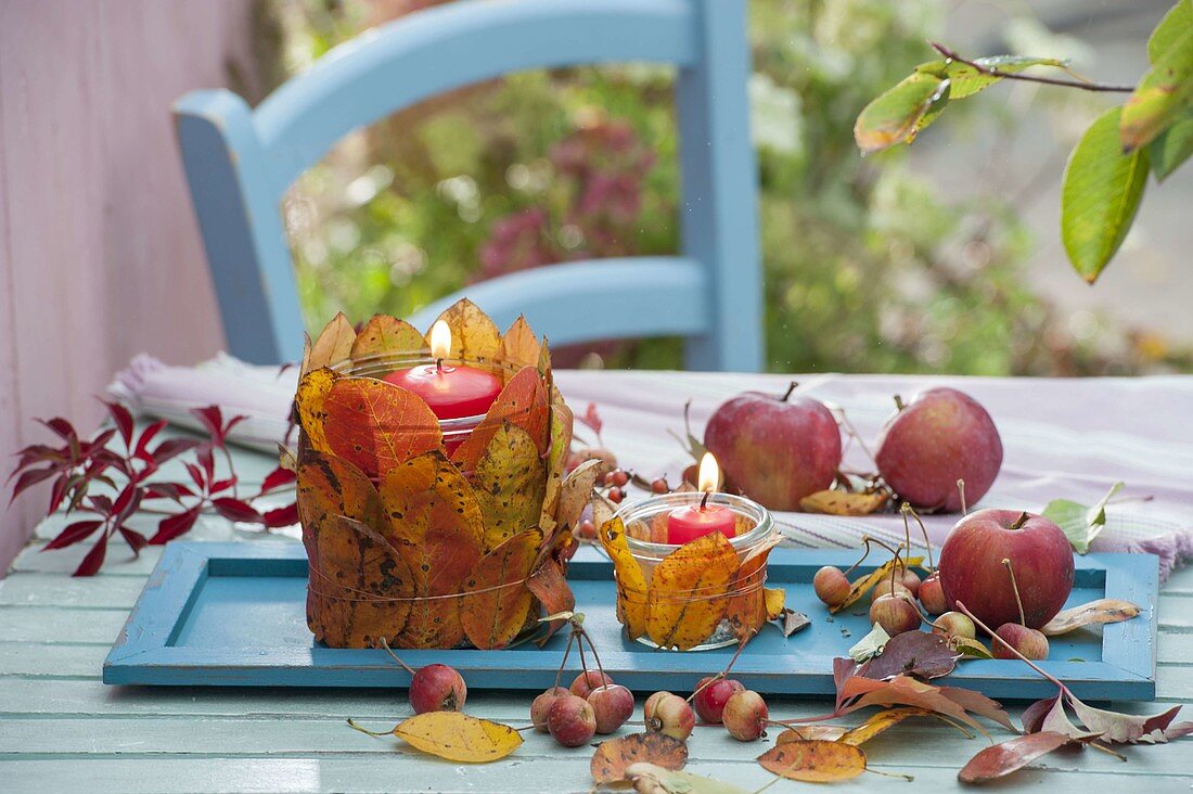 Herbst-Tischdeko mit Blätter-Windlichtern und Äpfeln