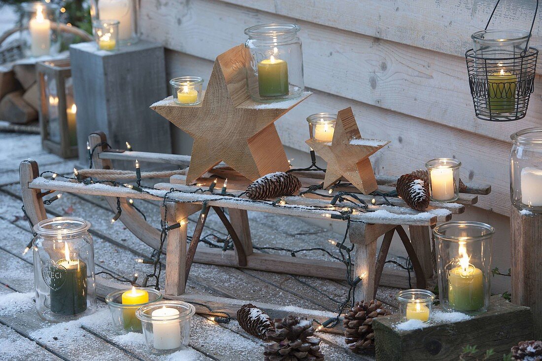 Weihnachtliche Terrasse mit Schlitten , Lichterkette, Holz - Sternen