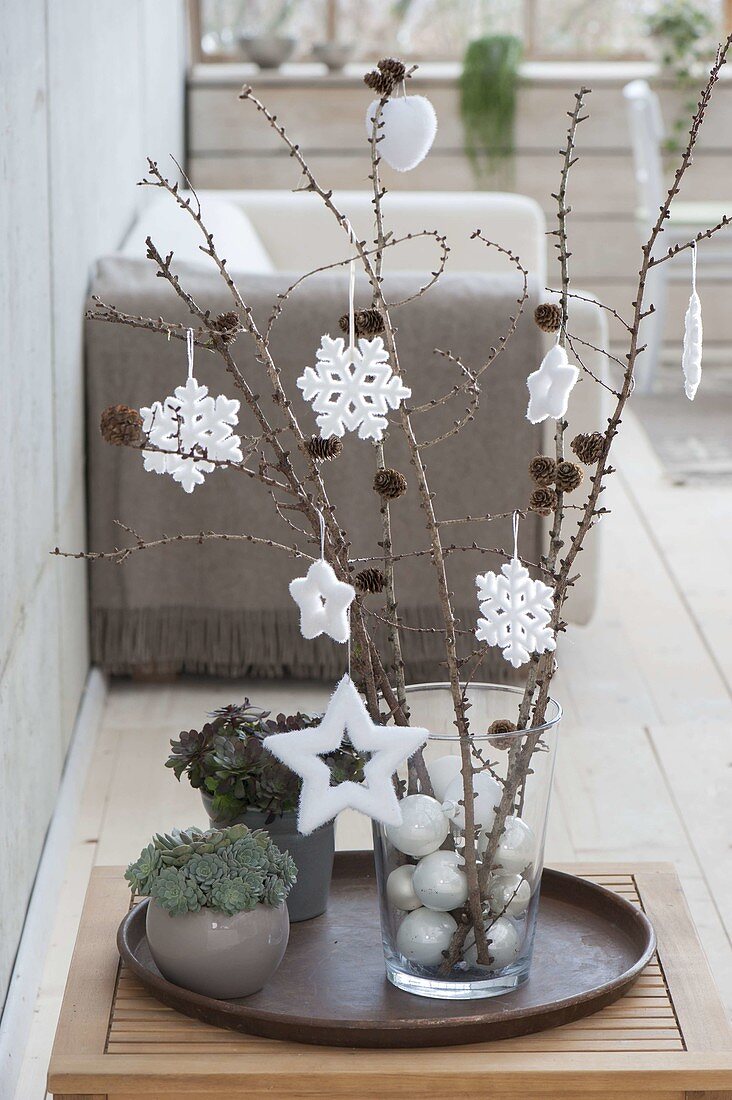 Larix branches in glass vase with white tree balls