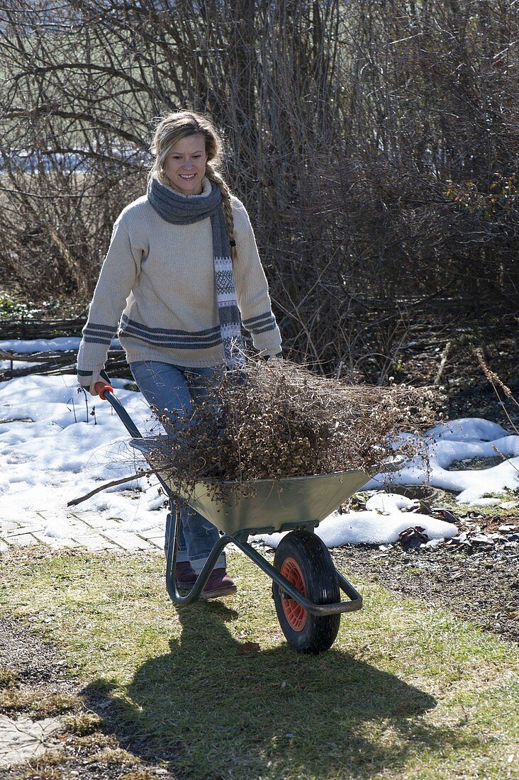 Woman is doing spring cleaning in the garden