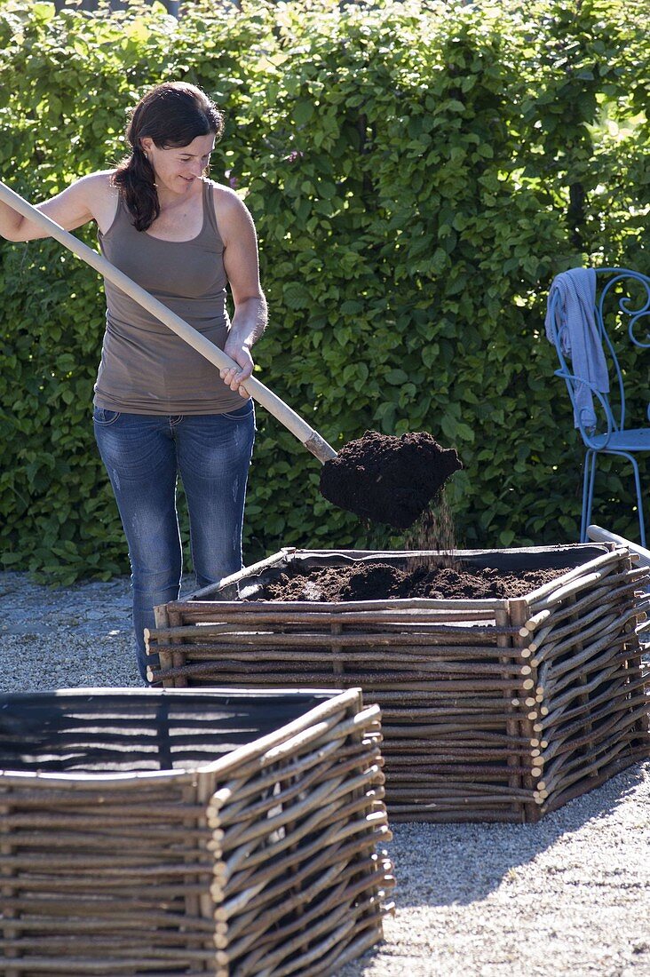 Gravel terrassse with raised beds made of hazelnut rods