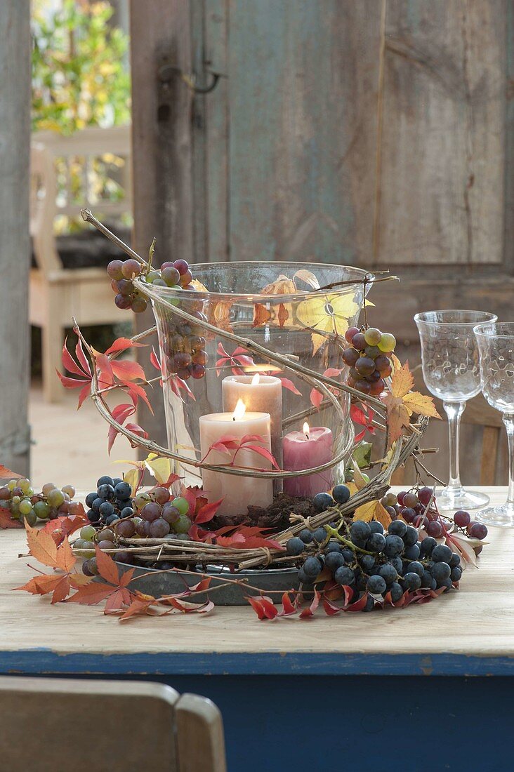 Grosses Glas mit Kerzen als Windlicht, dekoriert mit Weintrauben
