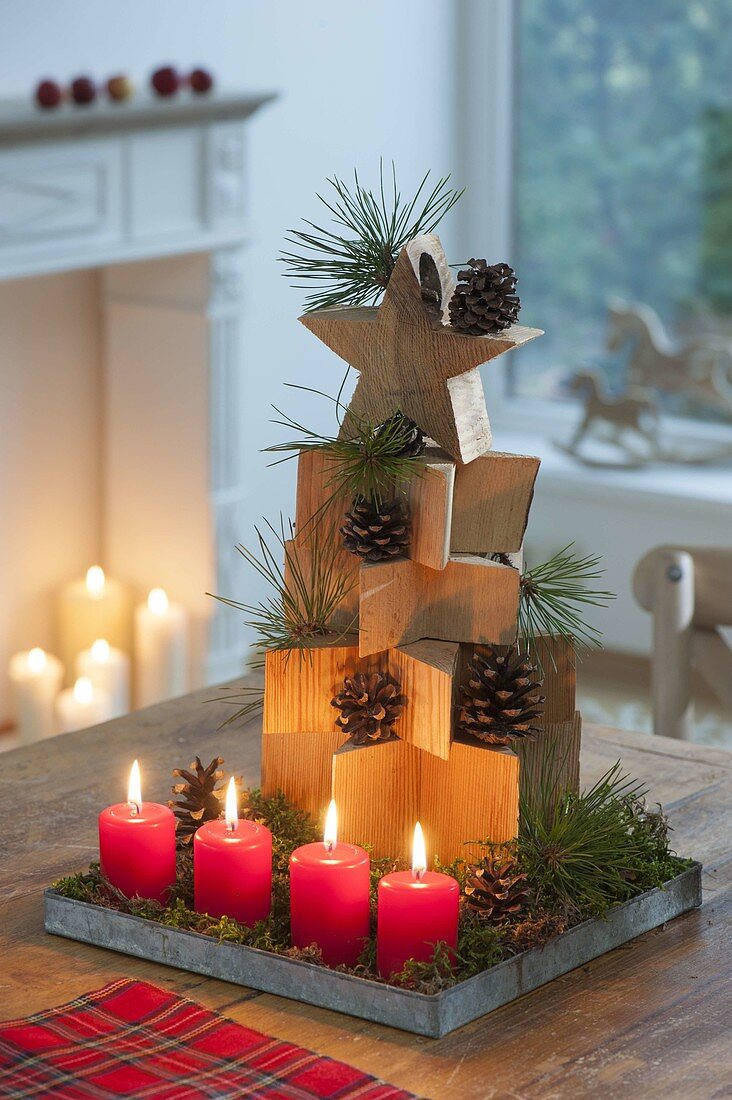 Stacked wooden stars as a fir tree, cones and branches