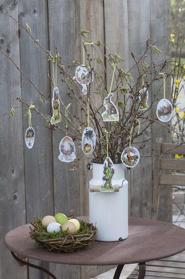 Easter bouquet of branches in old milk can, decorated with Easter wafers