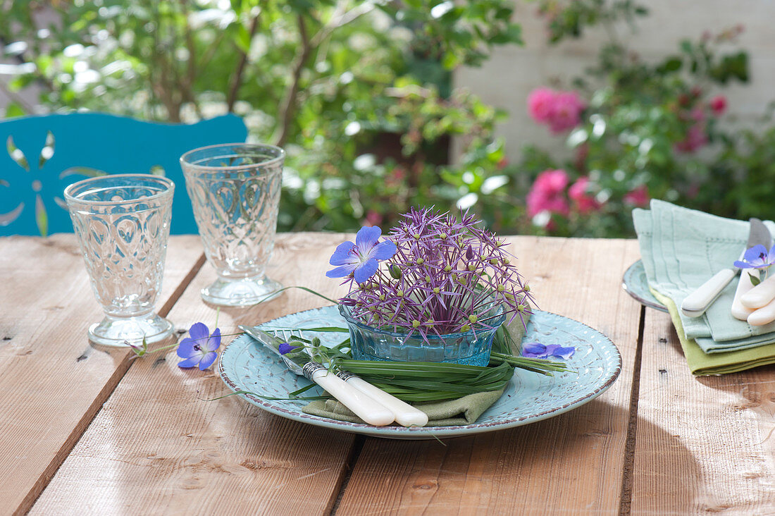 Glass bowl with Allium (garlic) flower and geranium