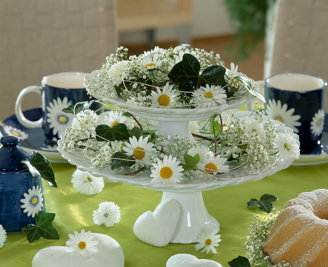 Etagere with daisy flowers, gypsophila and ivy leaves