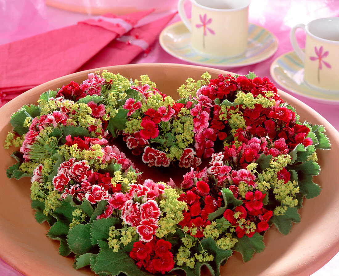 Summer wreath of heart-shaped sticking dough with Dianthus