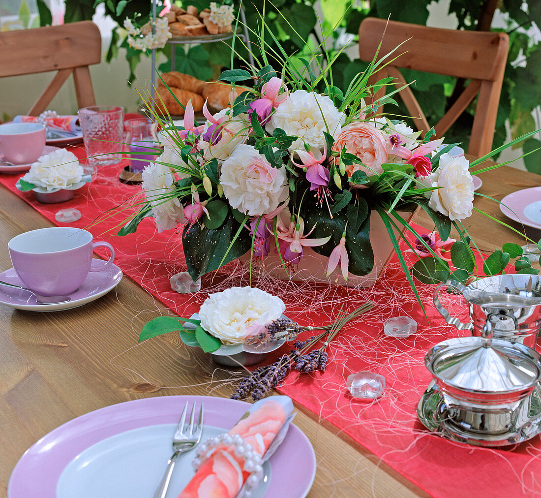 Table decoration with roses, fuchsias, grasses