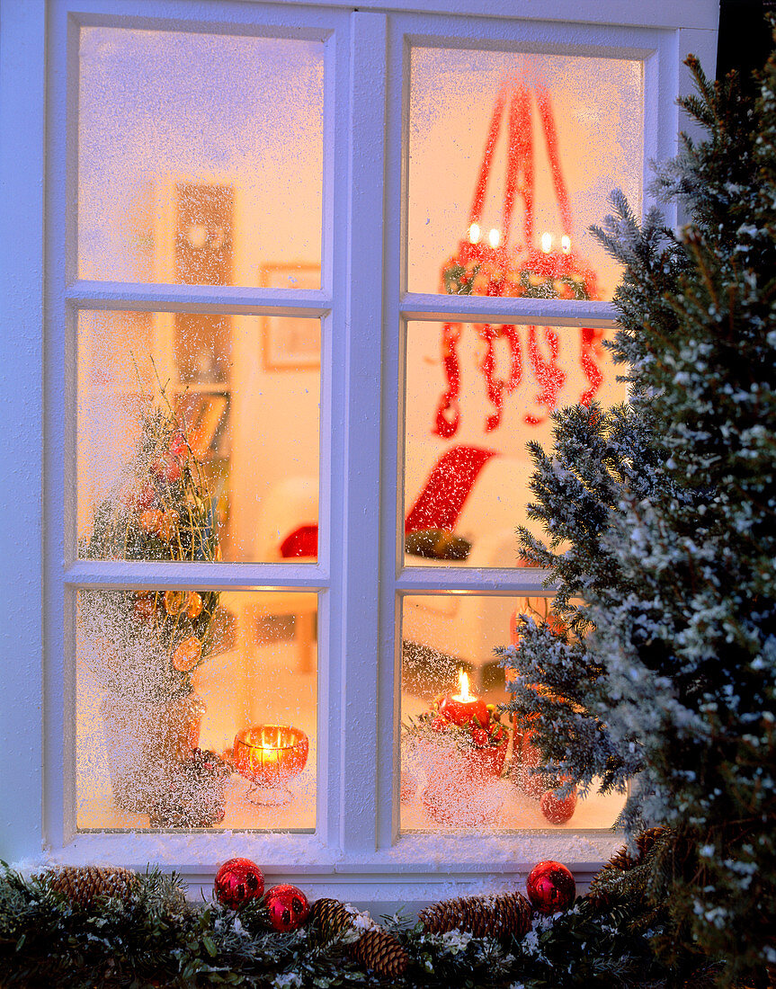 Blick durch ein Fenster in weihnachtlich geschmücktes Zimmer