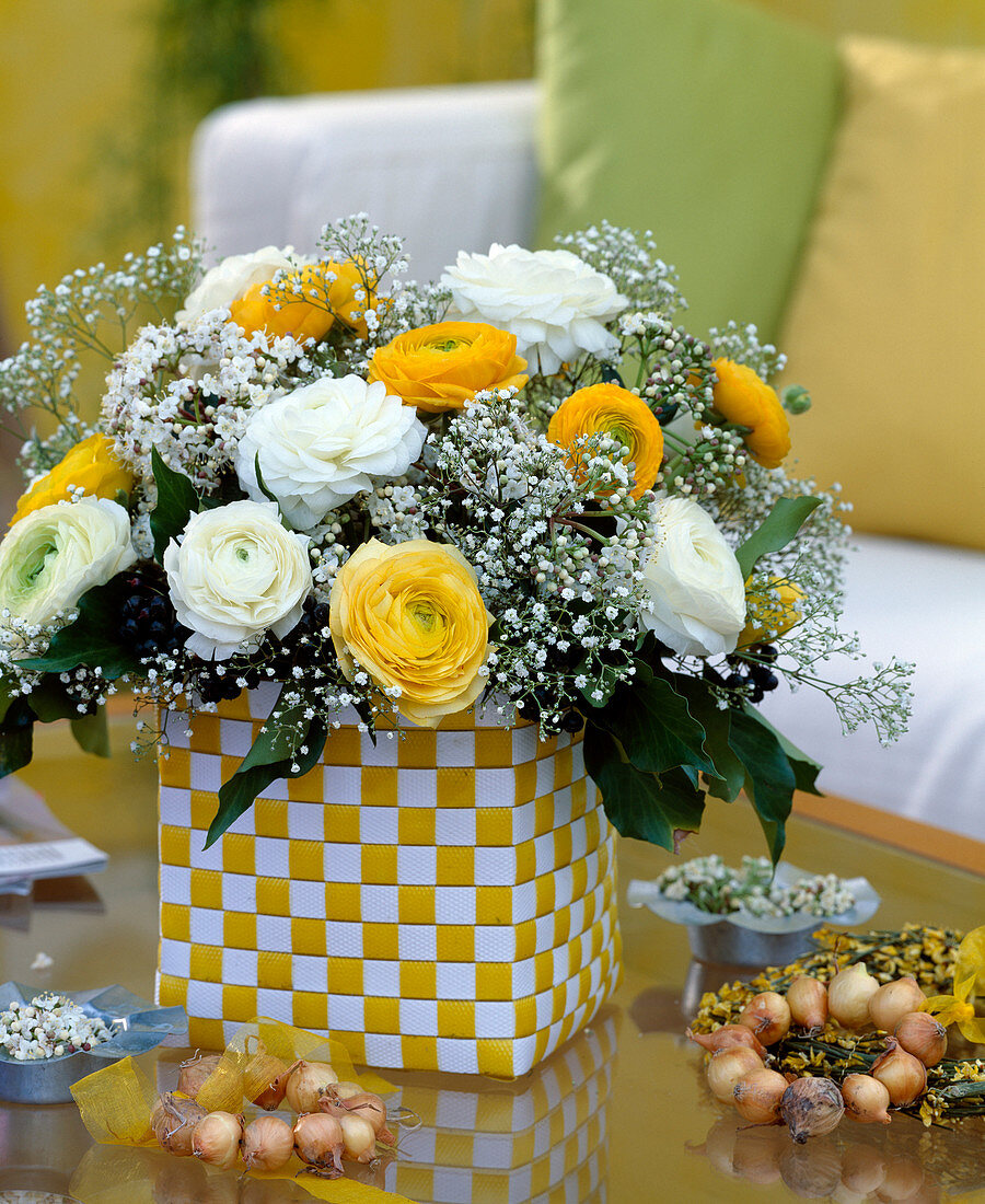 Bouquet maade of yellow and white ranunculus, white gypsophila