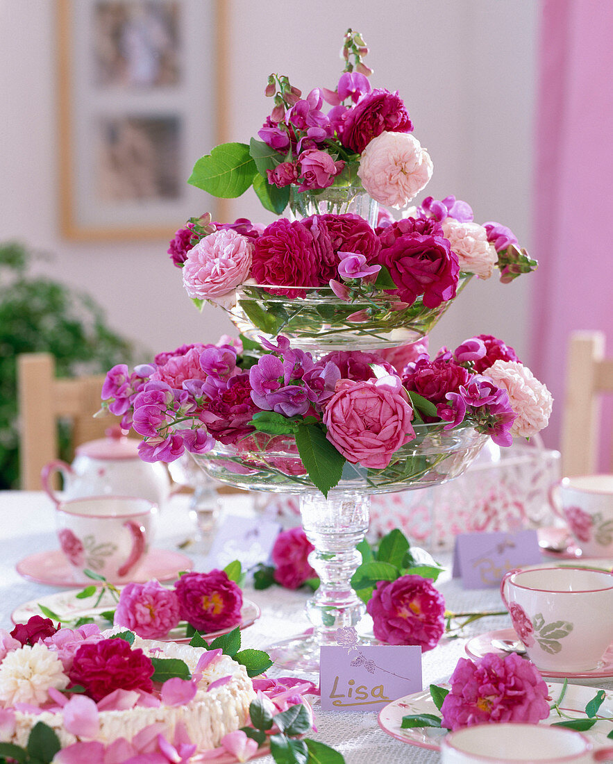 Tischdekoration mit Etagere aus Glasschalen gefüllt mit Rosenblüten
