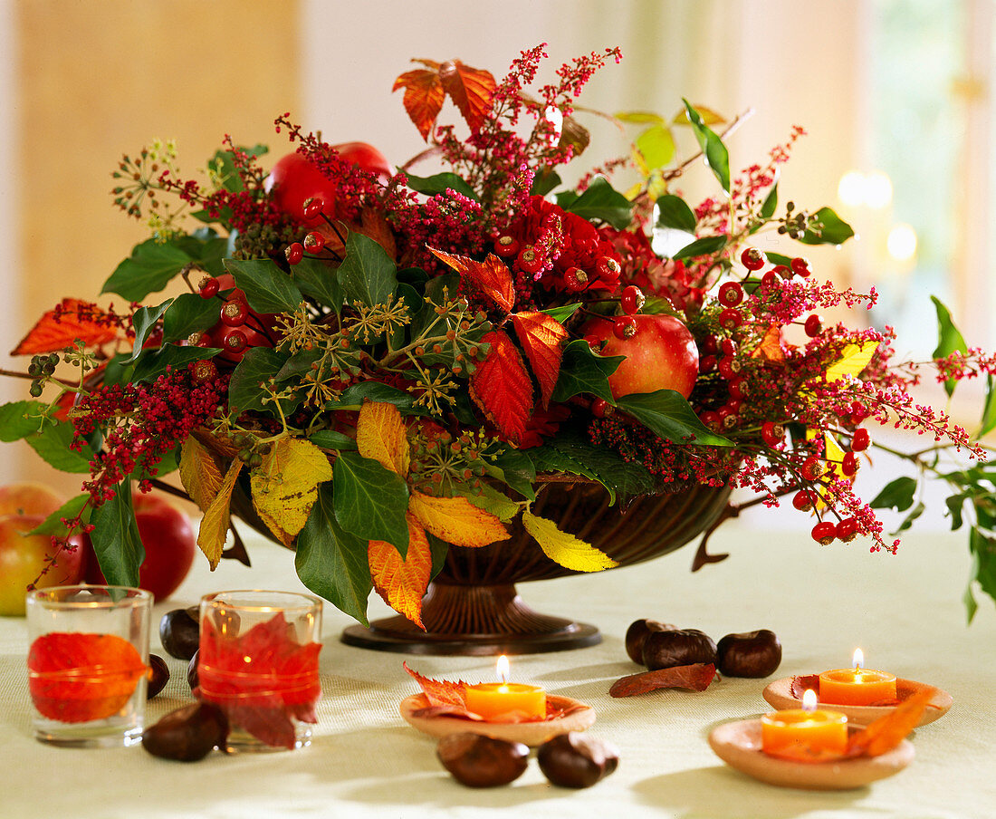 Autumn arrangement with berry decoration, colorful leaves and Erika