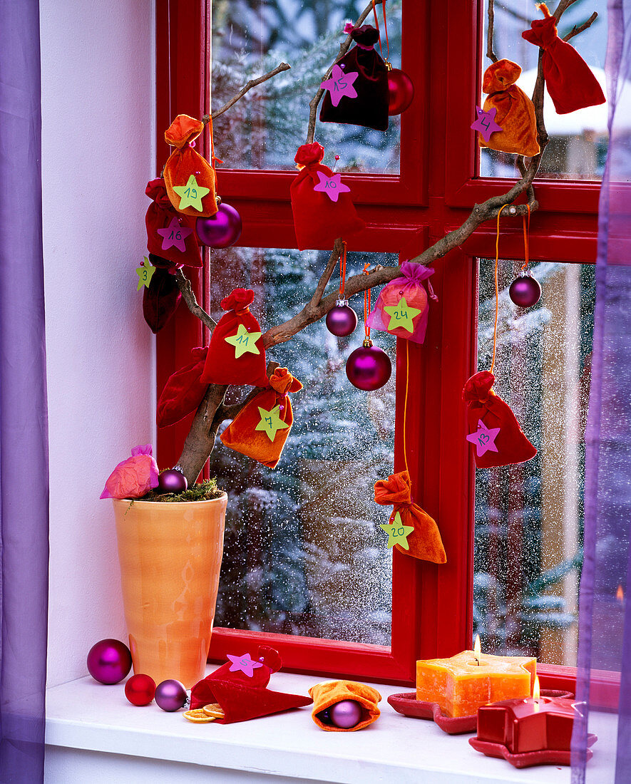 Advent calendar made of felt bags, star candles red and orange