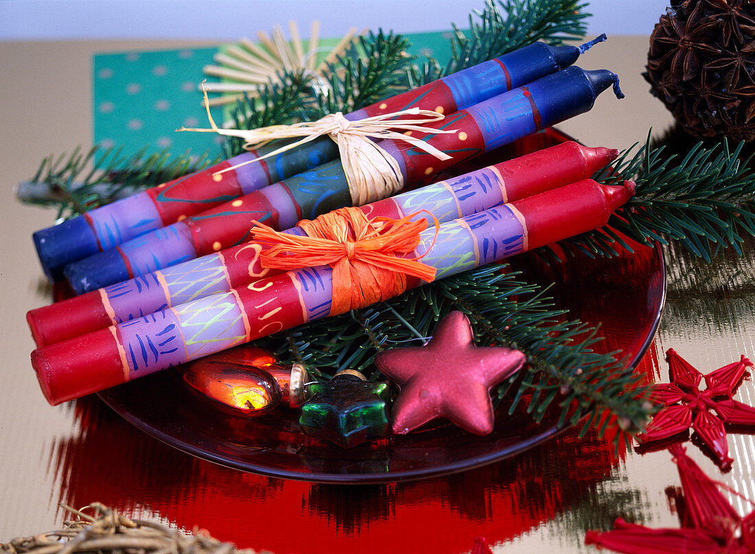 Rote und Blaue Kerzen als Geschenk weihnachtlich dekoriert