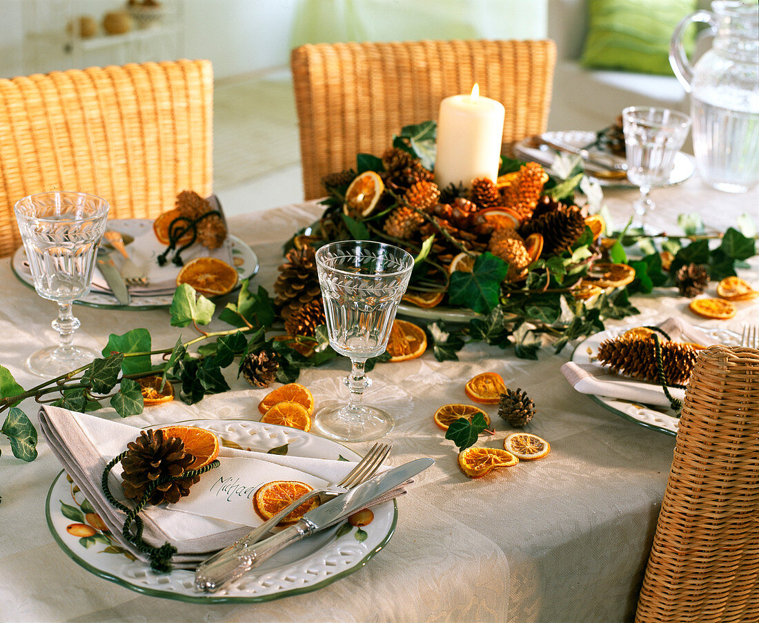 Table decoration with orange slices, pine cones, ivy banks, spruce cones