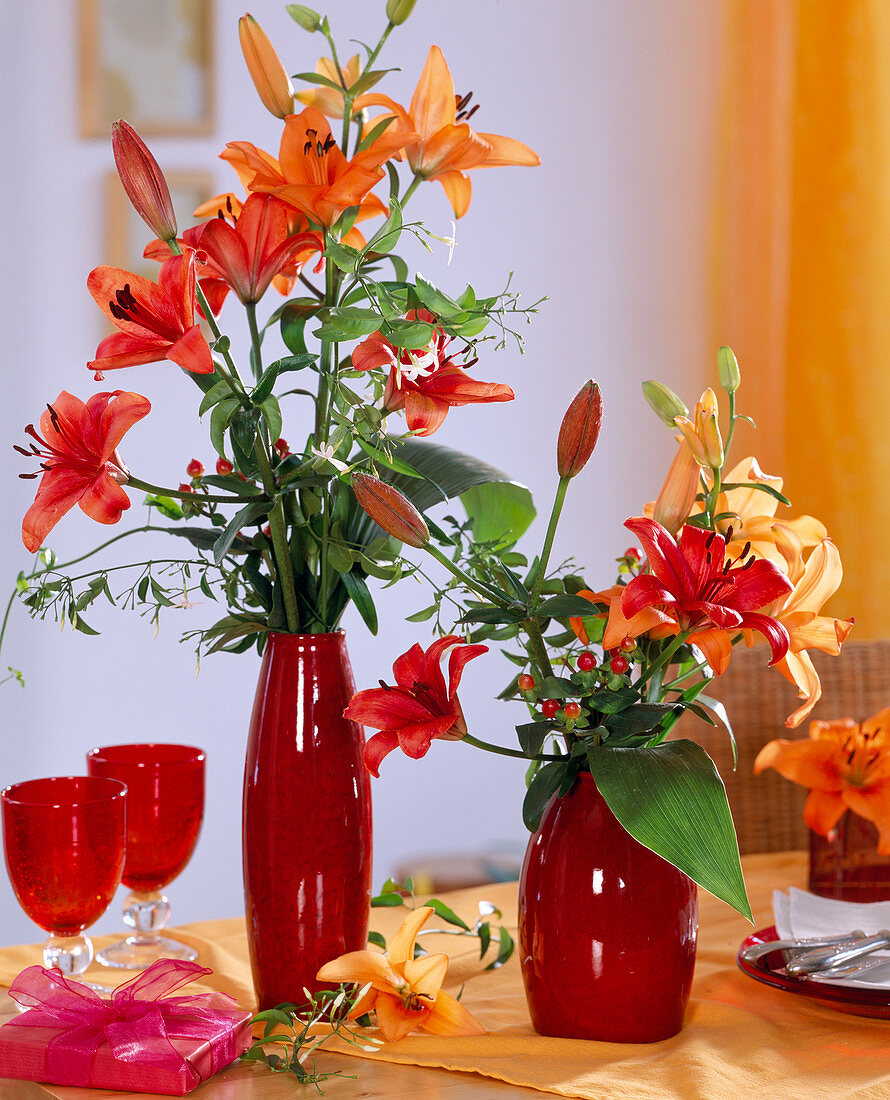 Lilium 'Tresor', 'Solfarino' / Lilien rot und orange in roten Vasen