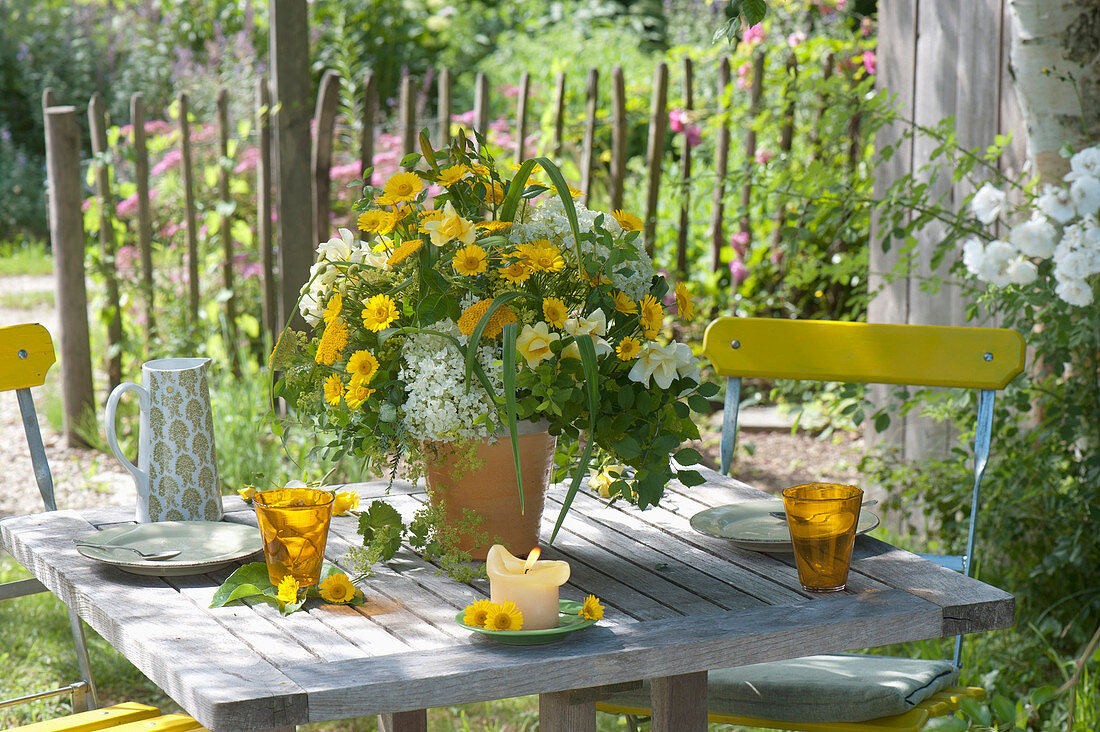 Yellow summer bouquet on table in the garden