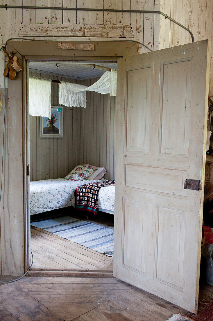 View into bedroom with twin beds through open panelled door