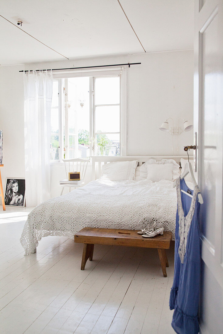 Bluse hängt an der offenen Tür zum Schlafzimmer in Weiß