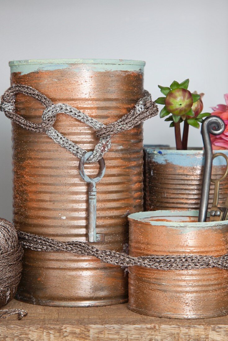 Recycelte Blechdosen bronzefarben bemalt mit gestrickter Kordel
