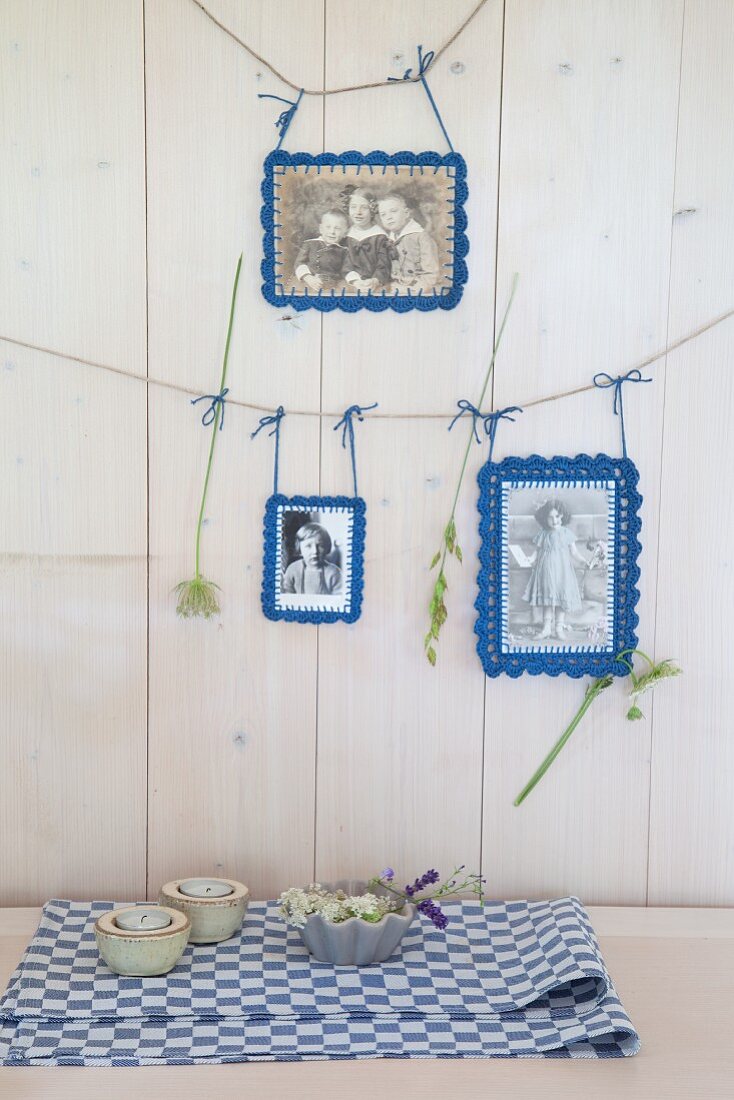 Old photos with crocheted picture frames hung from lines