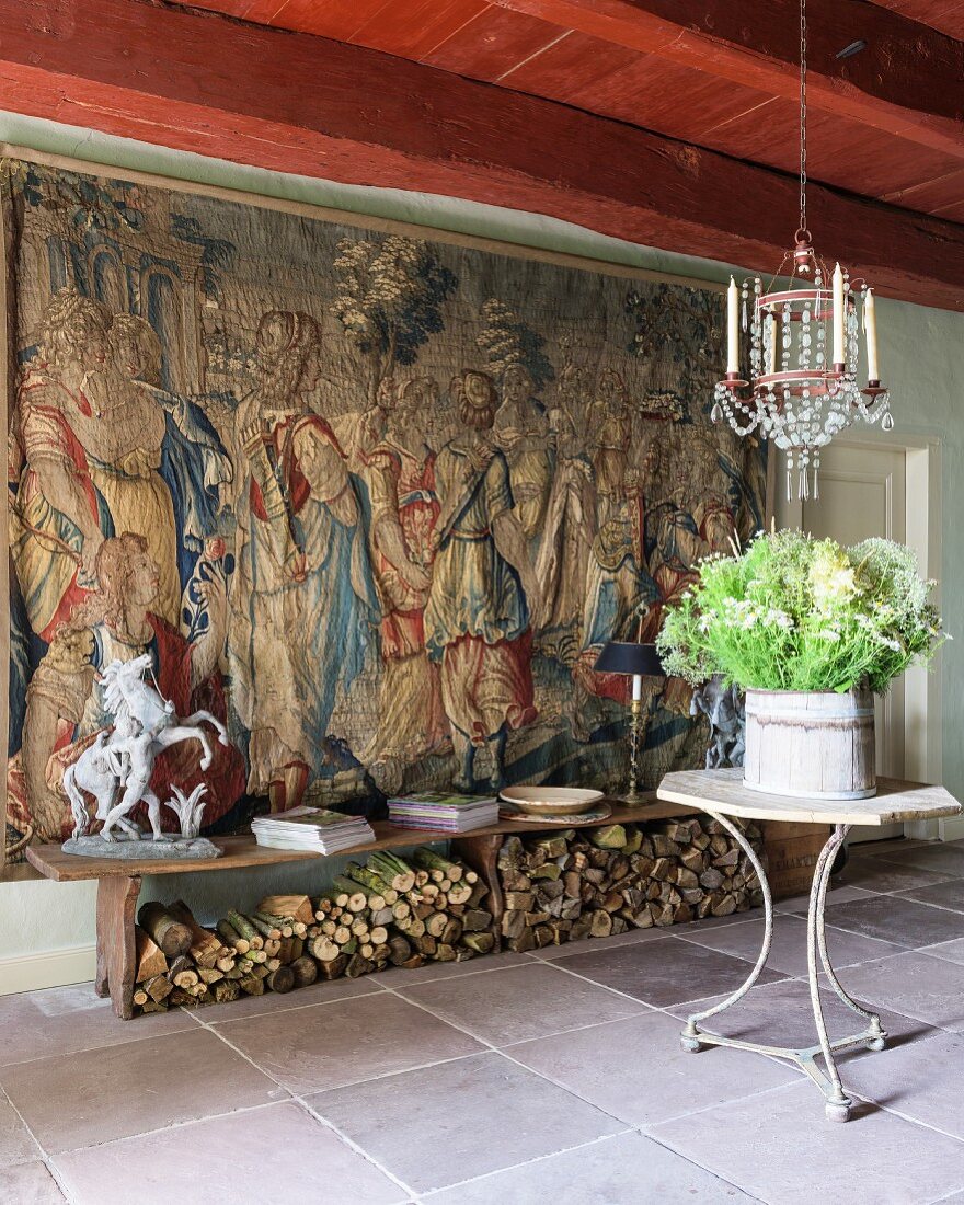 Foyer mit flämischer Tapisserie, Holzbank und Tischchen unter französischem Kronleuchter