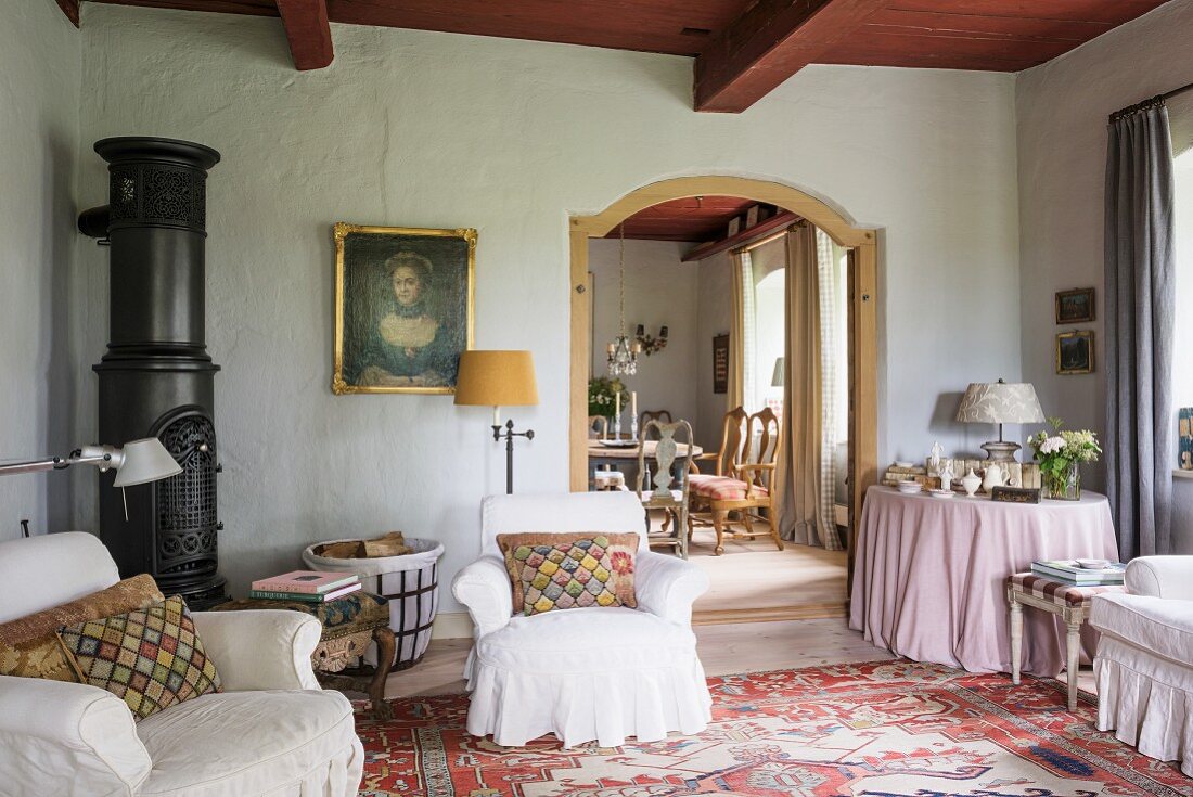 Round iron stove, loose-covered armchairs and Heriz rug