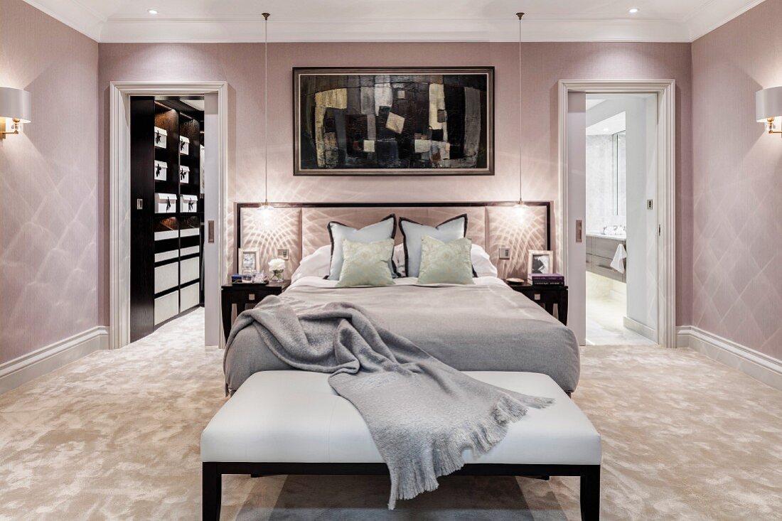 Glamorous bedroom in pastel shades with bench at foot of bed
