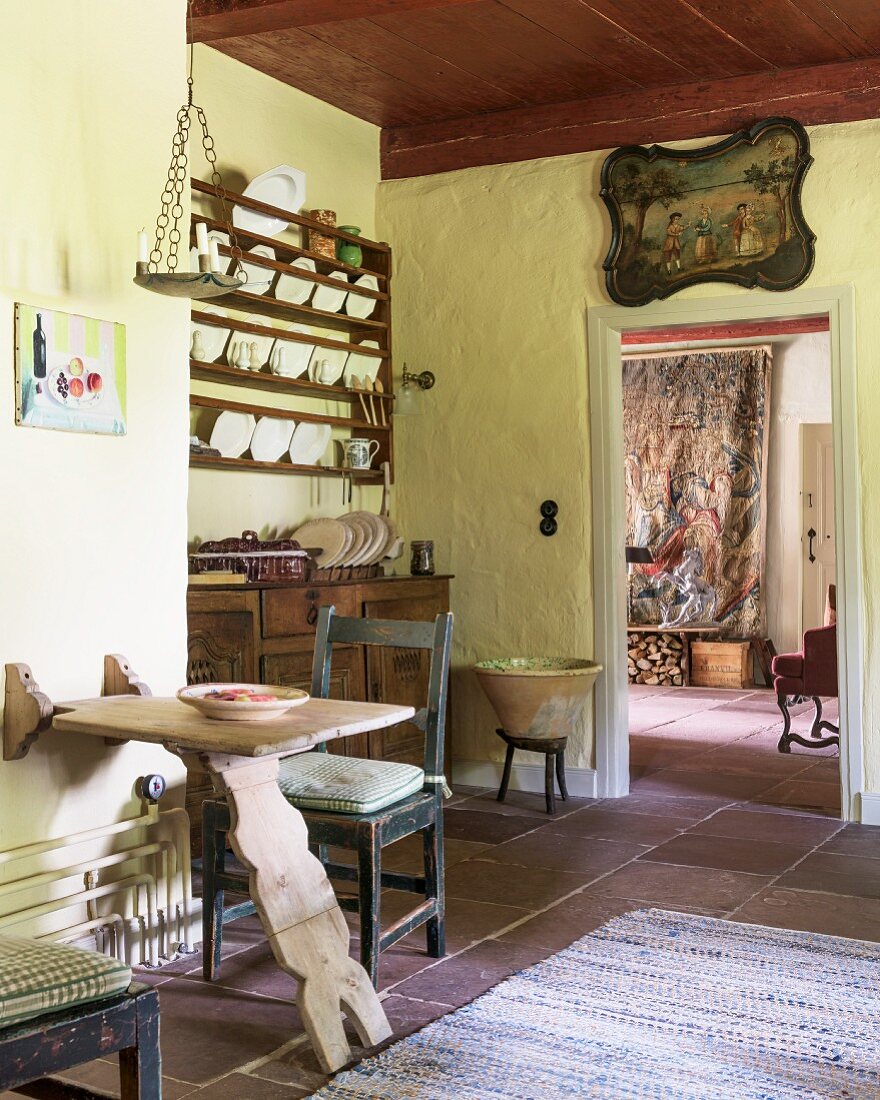 Vintage Küche mit Tellerregal, Holztisch und antikem Bild