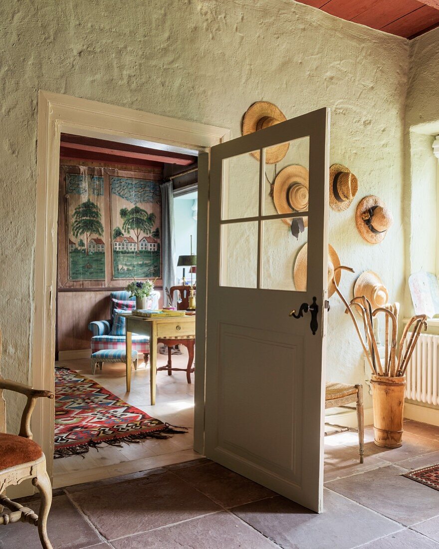 Old hats and walking sticksand door with glass panels in hallway