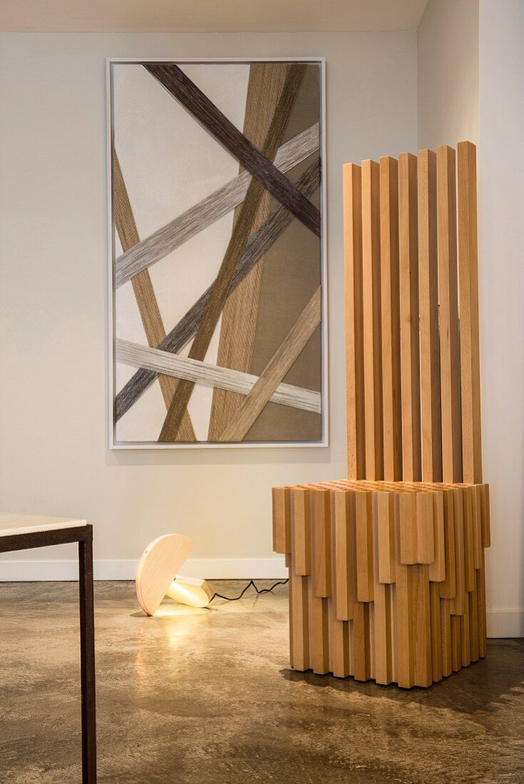 Modern wooden throne in front of cord artwork