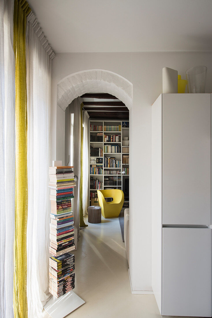 Vertical bookshelf next to doorway leading into living room