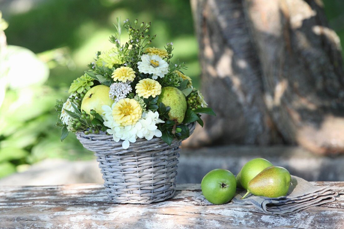 Gesteck aus Zinnie und Hortensien mit Birnen dekoriert