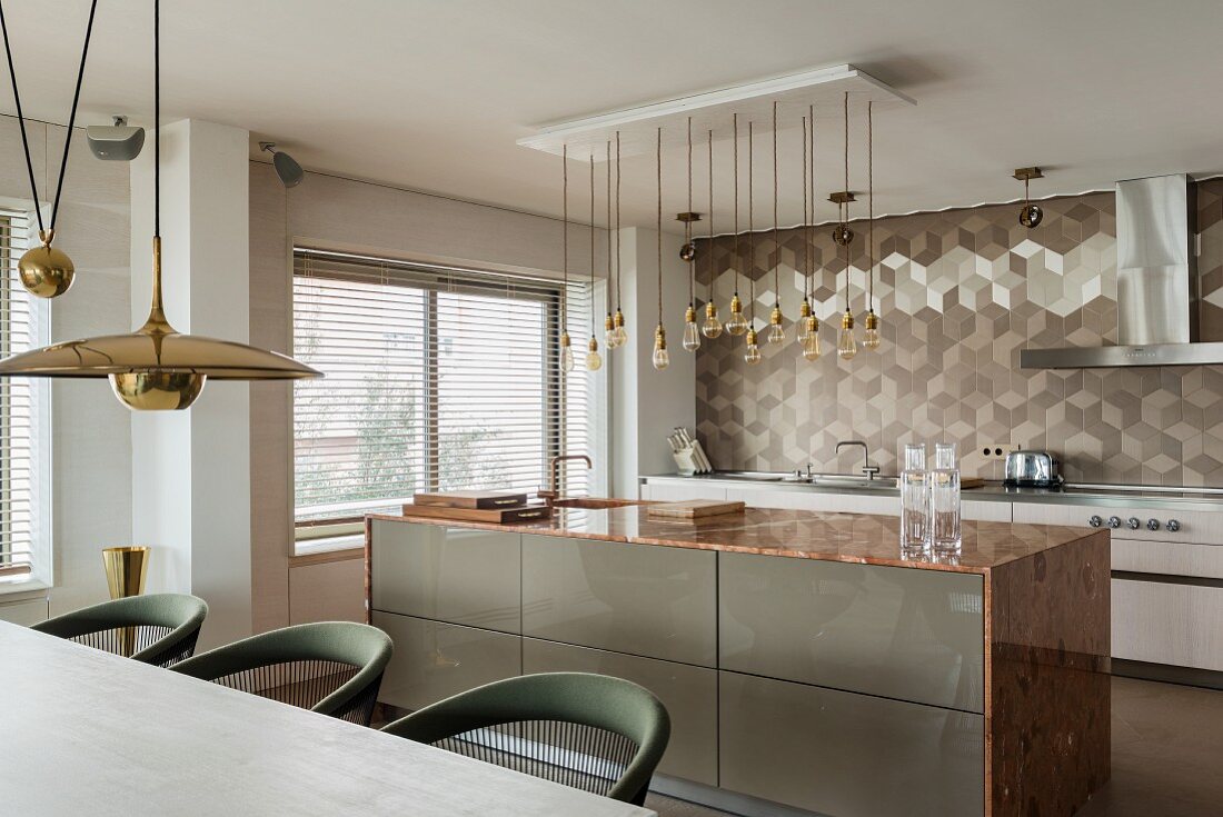 Edle, offene Küche mit Kücheninsel, Marmor-Küchenarbeitsplatte und geometrischem Wandfliesenmuster