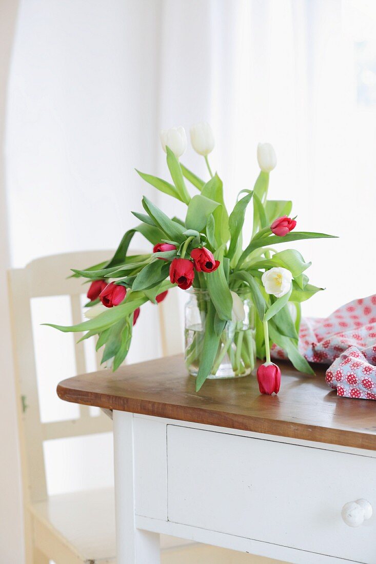 Vase of tulips on wooden table