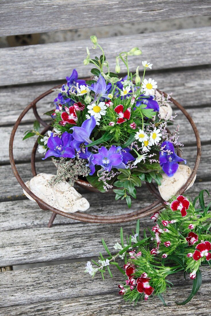 Arrangement of delphiniums and sweet Williams in metal dish