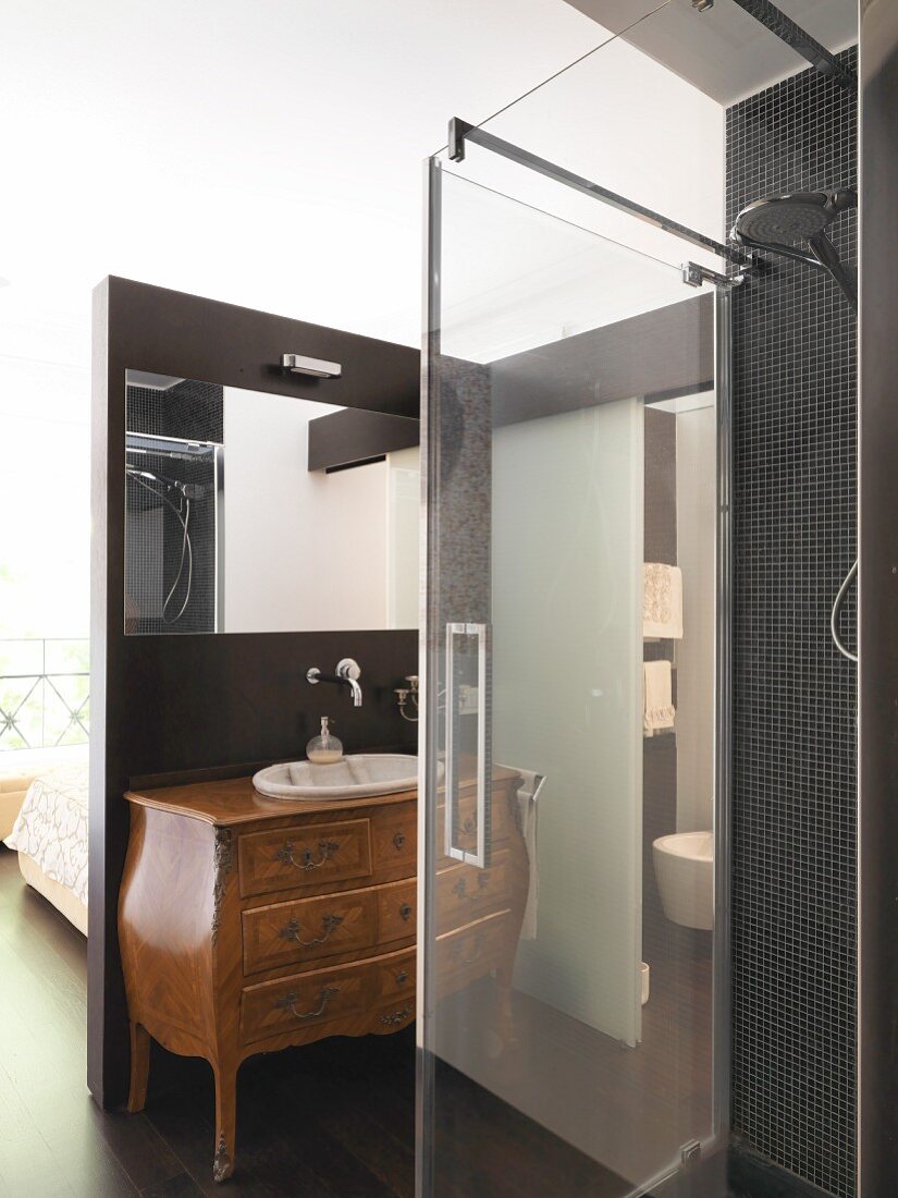 Washstand made from elegant, antique chest of drawers in modern, black ensuite bathroom
