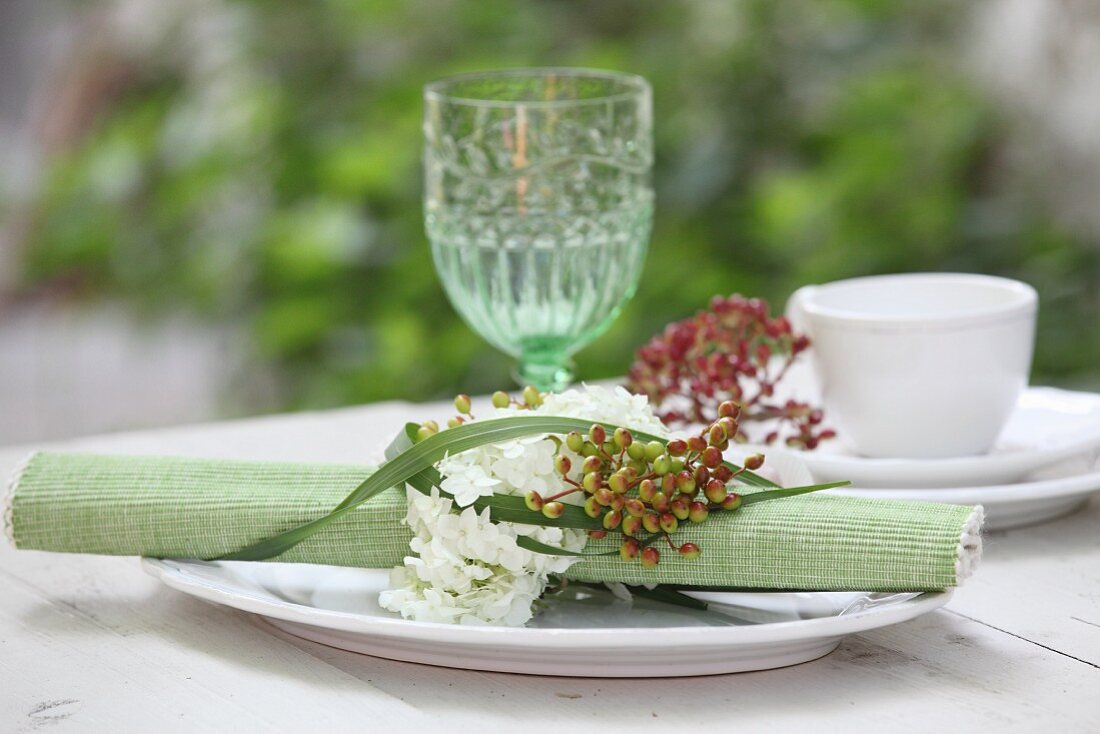 Gerolltes Tischset mit Serviettenring aus Blumen