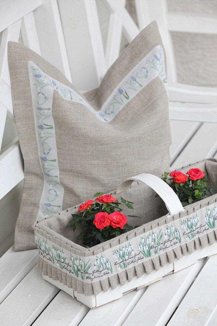 DIY-Kissenbezug aus Naturleinen mit Blumenborte und verziertes Spankörbchen mit Rosen