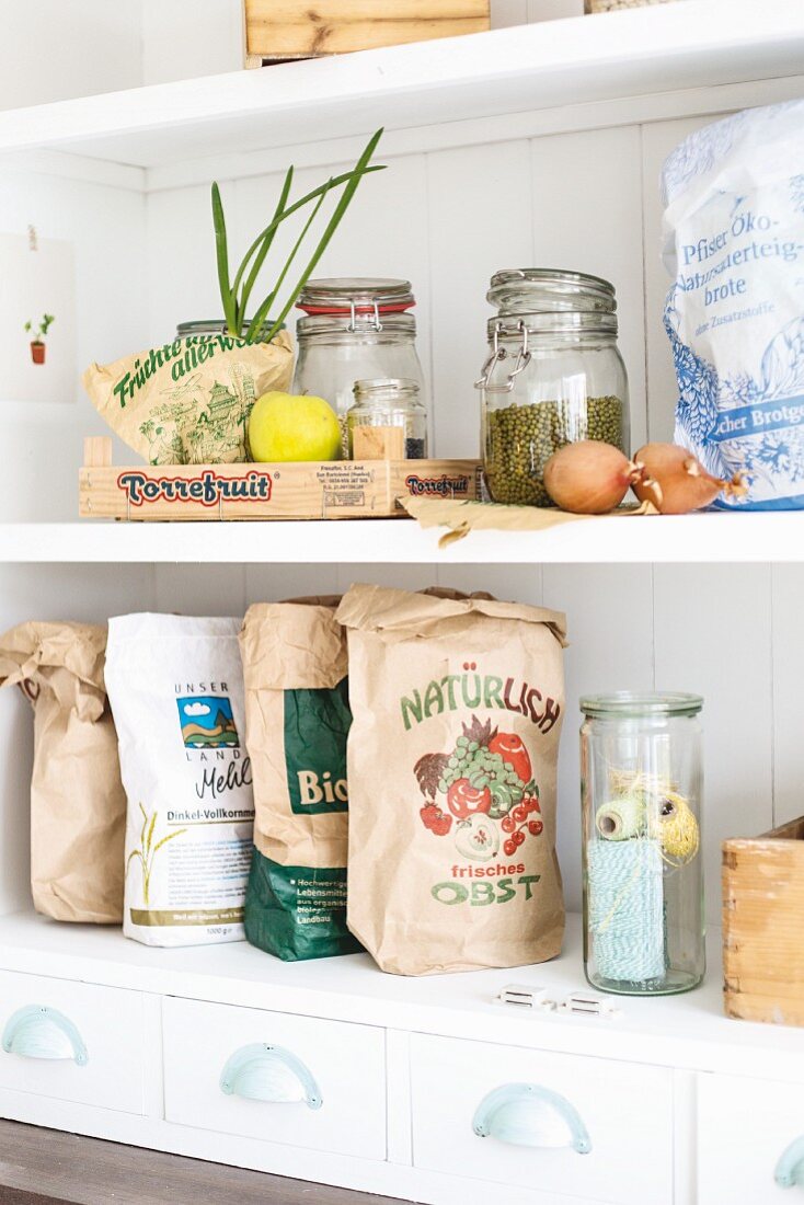 Küchenregal mit verschiedenen recycelten Papiertüten, Aufbewahrungsgläsern und Obstkistchen