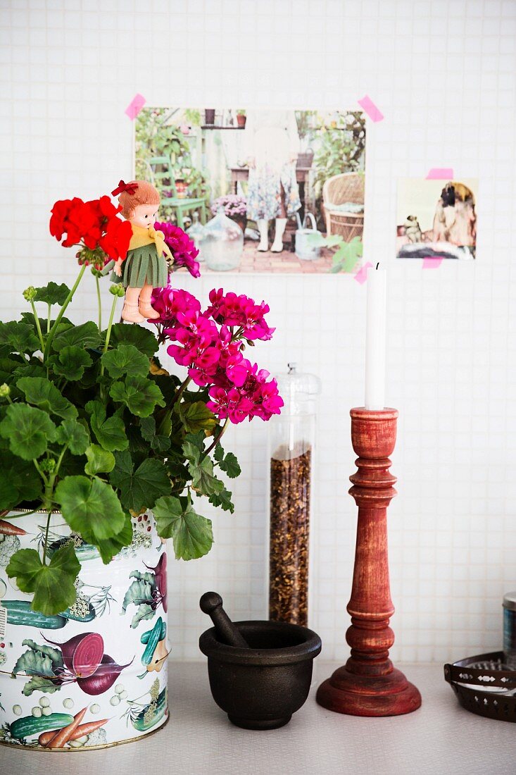 Potted geraniums, mortar and pestle, pepper mill and candlestick